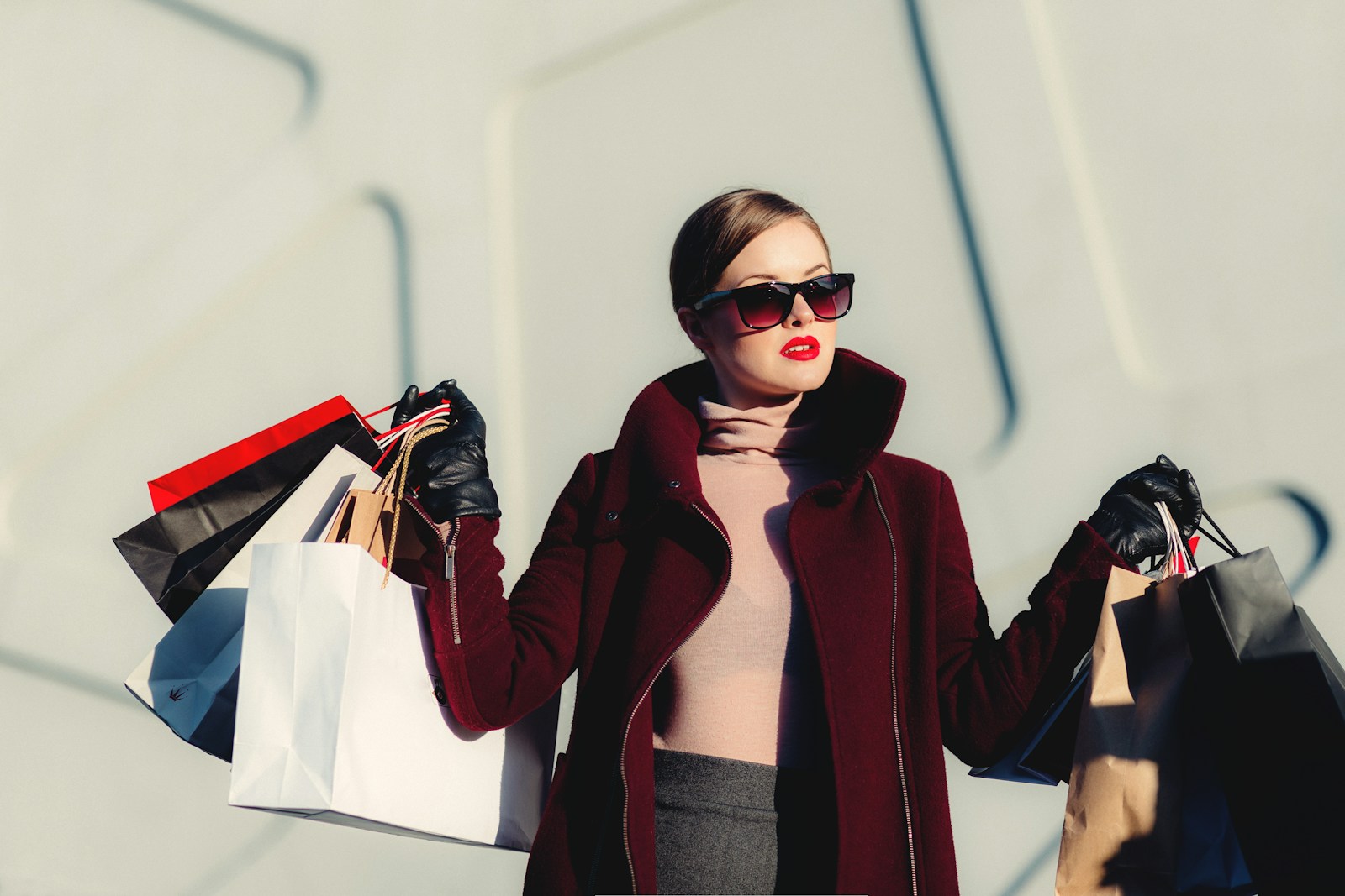 Mujer con gafas de sol y bolsas de compras